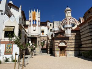 Zdjęcie przedstawiające dziedziniec, wejście do kaplicy chrzcielnej kościoła Església St. Romà oraz budynek obok kościoła w lloret de Mar, Hiszpania.