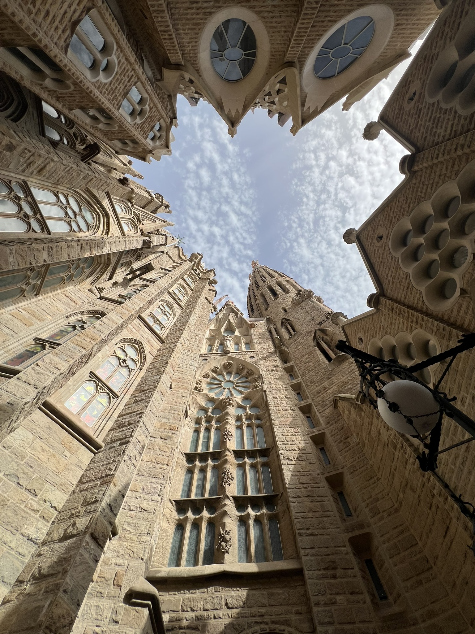 Mały dziedziniec kościoła Sagrada Familia w Barcelonie, przy wejściu do krypty, widok pionowo w górę, na niebo.